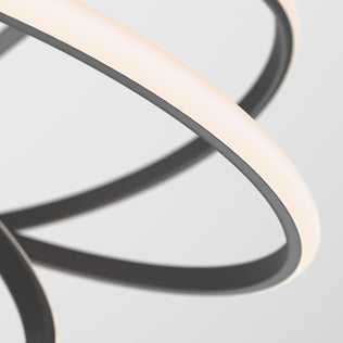 Close-up of the Artika Maelstrom LED pendant light, featuring interlocking curved strips in matte black with glowing white edges. Set against a white background, its abstract design delivers a striking, modern look.