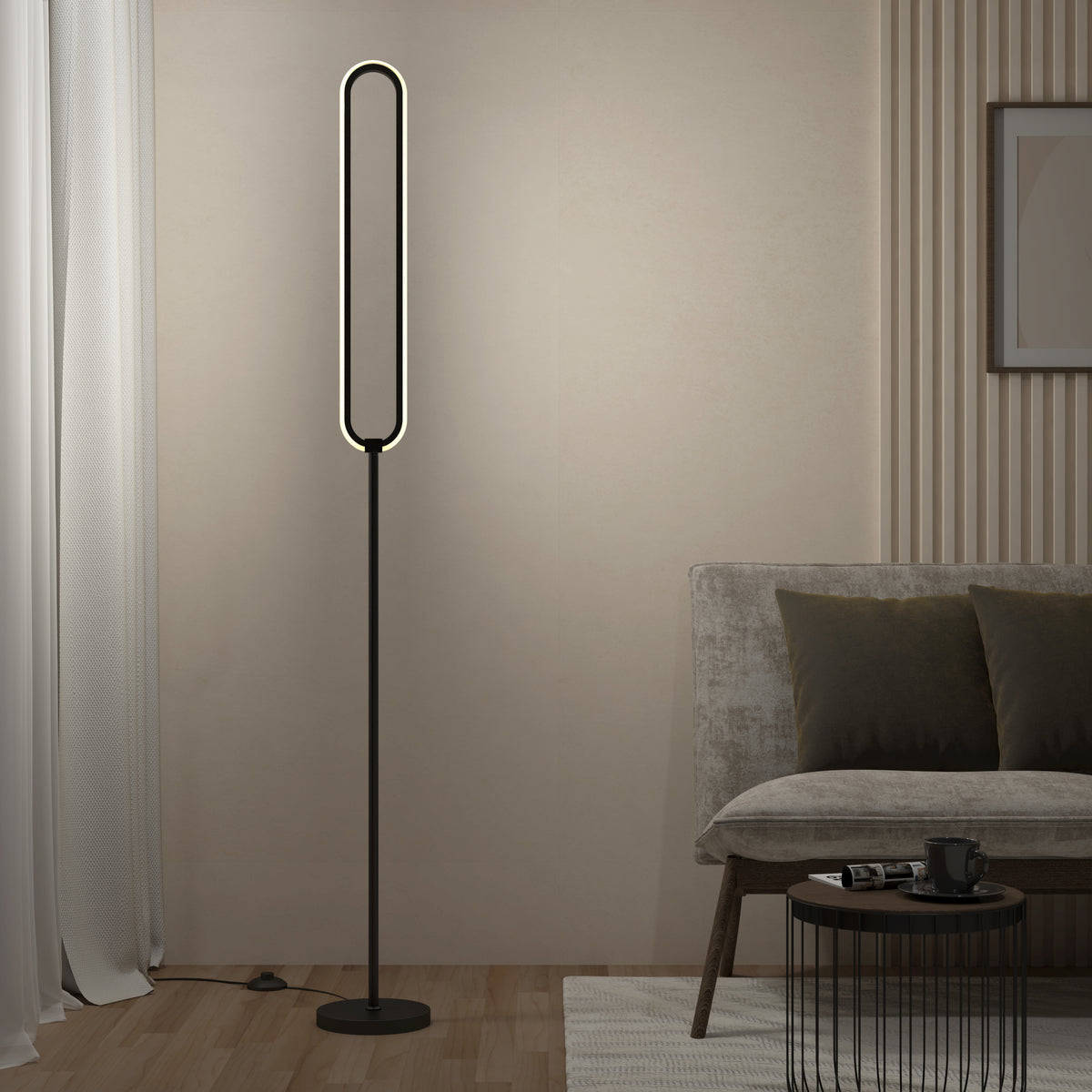 A modern living room corner with a minimalist oval-shaped floor lamp emitting soft light, a gray sofa with dark cushions, a round black coffee table, and neutral-colored decor.