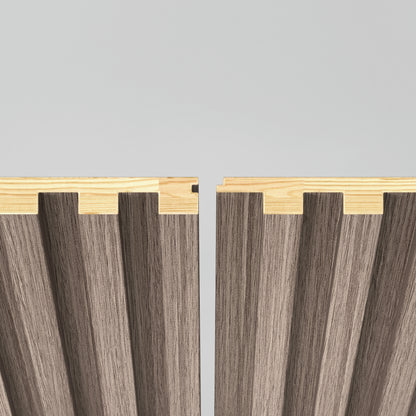 Two Panolok 30.67 ft wall panel kits by Artika, each with light oak edges and textured brown surfaces, stand vertically with a small gap, showcasing interlocking zigzag edges—reflecting minimalist Scandinavian style.