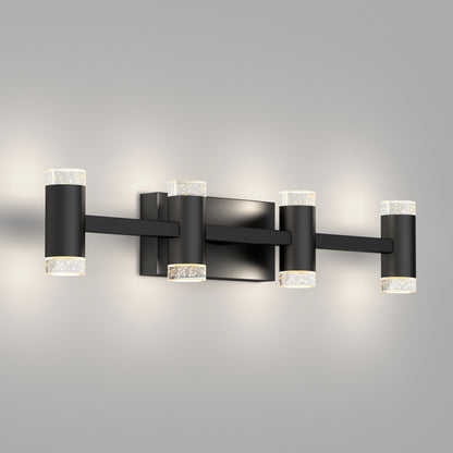The Artika Mist modern LED bathroom vanity light features four cylindrical lights with clear textured glass ends on a black rectangular base, shown mounted against a light gray wall.