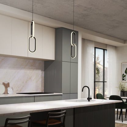 Modern kitchen with gray and white cabinets, marble backsplash, black faucet on the island, Artika’s Catena LED pendant light (5 CCT), large window with sheer curtains, and a dining area featuring green chairs.