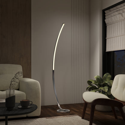 A modern living room includes the Artika Arc LED Floor Lamp with dimmable soft light, a beige armchair, sofa, black coffee table, green plant, and large windows with white blinds for a cozy minimalist atmosphere.