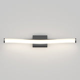A modern wall-mounted light fixture with a gently curved, elongated frosted tube attached to a rectangular black base, emitting a soft white glow against a light gray wall.