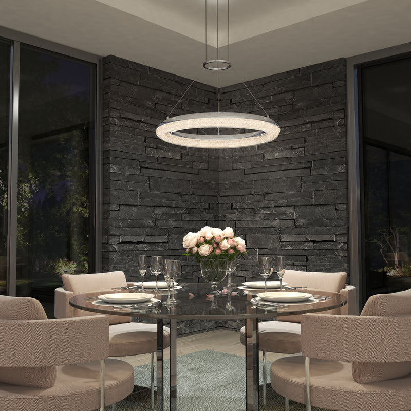 A modern dining room features a round glass table with four beige chairs, pink roses in a vase, elegant table settings, and the Artika Famous Optical LED pendant light 5 CCT. Dark stone walls and large windows complete the scene.