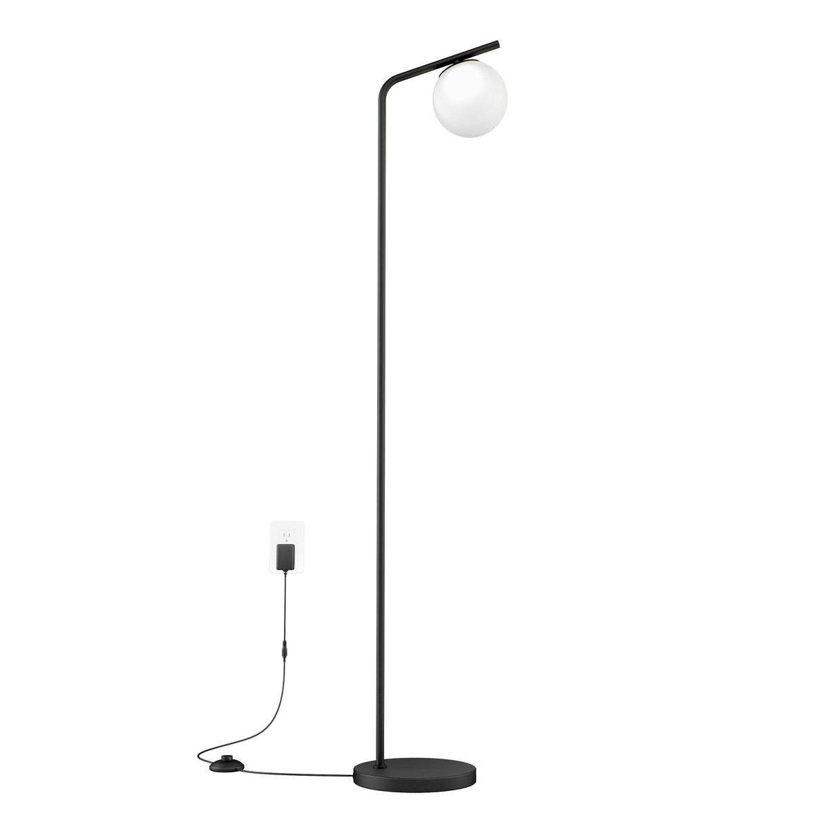 A modern black floor lamp with a round base and a slim, angled pole, featuring a spherical white lampshade at the top. The lamp is plugged into a wall outlet with a visible power cord and foot switch.