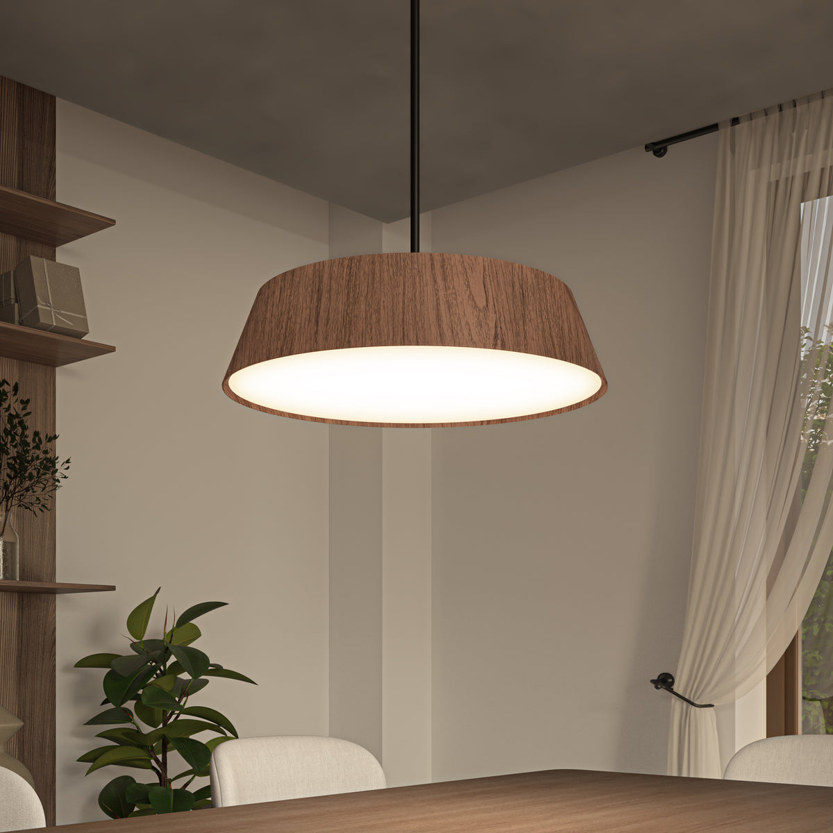 A modern dining room with a wooden table, beige chairs, a large wood-trimmed pendant light, potted plant, shelves with decor, and sheer curtains over a window letting in natural light.