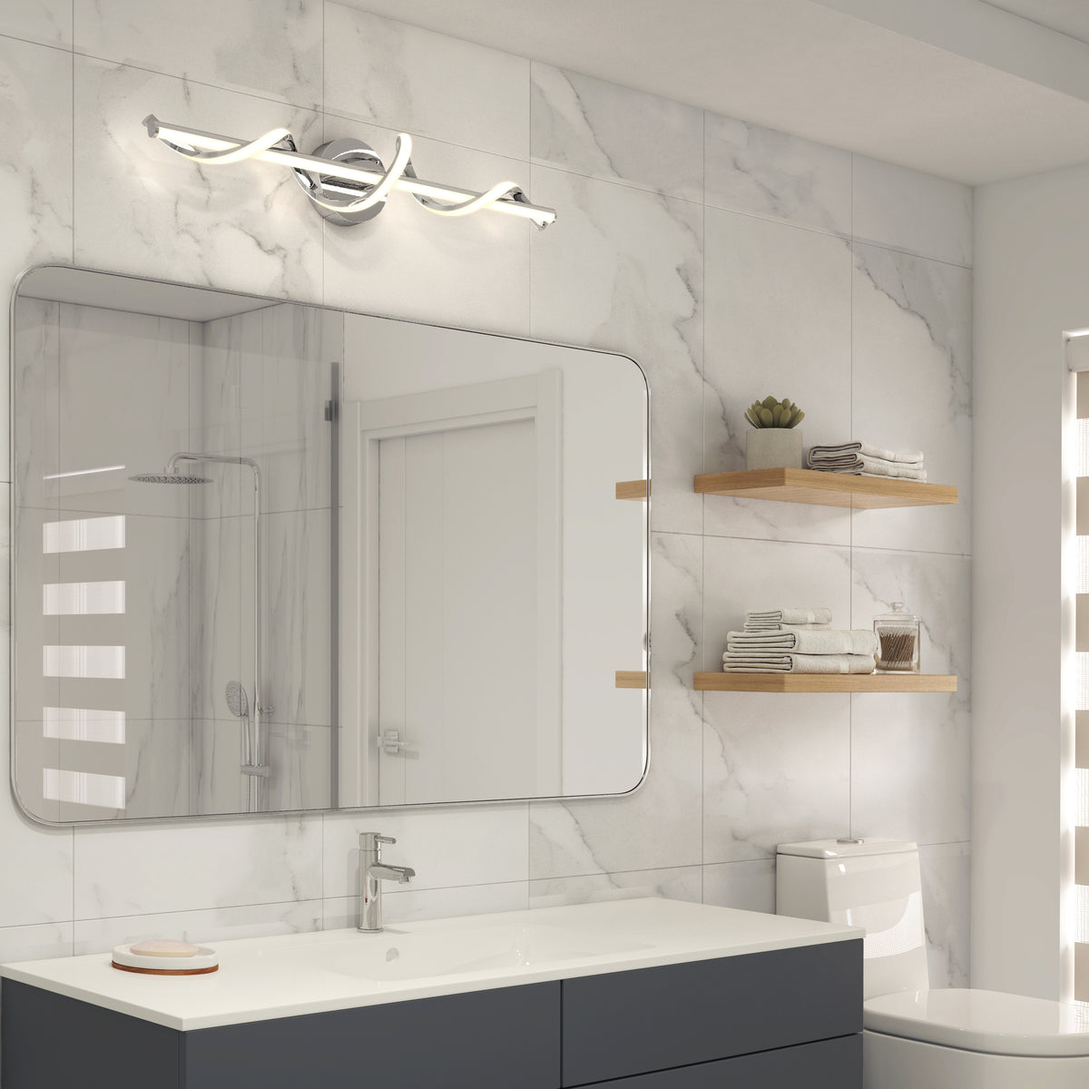 Modern bathroom with marble walls, a large rectangular mirror above a sink, a sleek chrome light fixture, toilet, wooden shelves with towels and decor, and a glass shower reflected in the mirror.