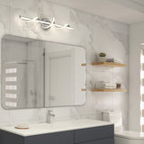 Modern bathroom with marble walls, a large rectangular mirror above a sink, a sleek chrome light fixture, toilet, wooden shelves with towels and decor, and a glass shower reflected in the mirror.