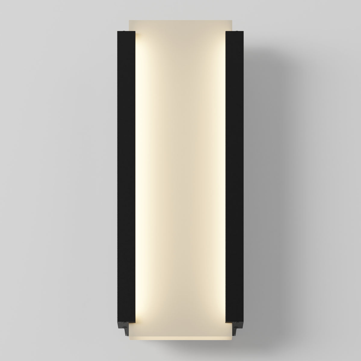 A modern wall sconce with a rectangular, vertical design featuring black side panels and a soft, warm light glowing from the center against a light gray wall.