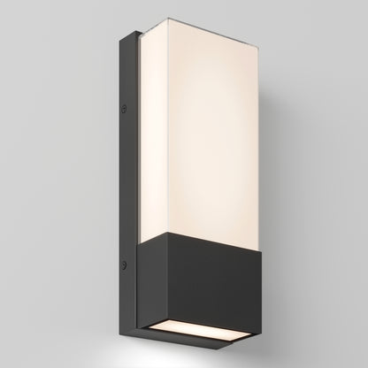 The Artika Dixon indoor-outdoor LED wall light features a modern rectangular design with a black base and frosted white glass shade, mounted on a light gray wall and emitting soft, even illumination.