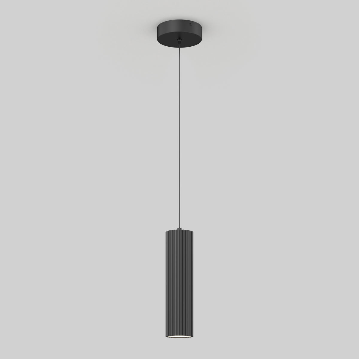 A modern black pendant light with a cylindrical, vertically grooved shade hanging from a thin cord attached to a round ceiling mount, set against a plain light gray background.