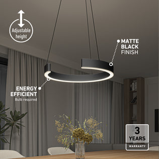 The Artika Vance modern LED pendant light 3 CCT with a matte black finish hangs above a dining table adorned with flowers. Features include adjustable height, energy efficiency, and a 3-year warranty. Room also has curtains and shelves.