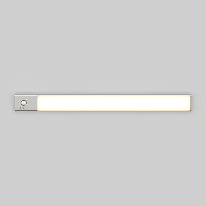 The Artika Outline under cabinet LED light 3CCT is a slim, rectangular fixture with a silver control panel and button on the left side, mounted on a plain light gray wall.