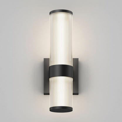 The Artika Mirado modern LED wall sconce 5 CCT features two vertically stacked cylindrical diffusers, a black central band, and a black rectangular base, offering a soft, even glow against a light gray wall.