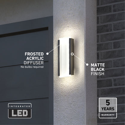 The Artika Blade indoor-outdoor LED wall light, featuring a frosted acrylic diffuser and matte black finish, is mounted beside a garage door. Integrated LED and 5-year warranty icons appear as the light glows softly on the wall.