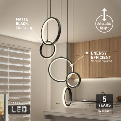 A modern kitchen features the Artika Elmo 5-light LED pendant with a matte black finish, circular design, adjustable height, 5 CCT options, energy efficiency, and a 5-year warranty; sunlight streams through window blinds.