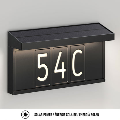 The Artika Bowen solar LED outdoor address wall light 5 CCT displays "54C" in illuminated white on a light gray background, with maintenance-free solar power details in English, French, and Spanish.