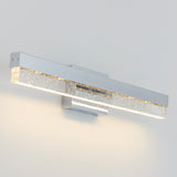 A modern wall-mounted LED light fixture with a rectangular, silver base and a frosted, bubble-filled acrylic bar, softly illuminating a white wall.