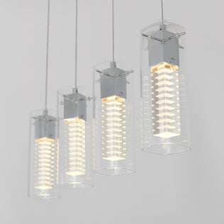 The Artika Hologram 4-light LED pendant features clear cylindrical glass shades and sleek metallic fixtures, suspended in a row against a light gray background, each casting a soft, warm glow.