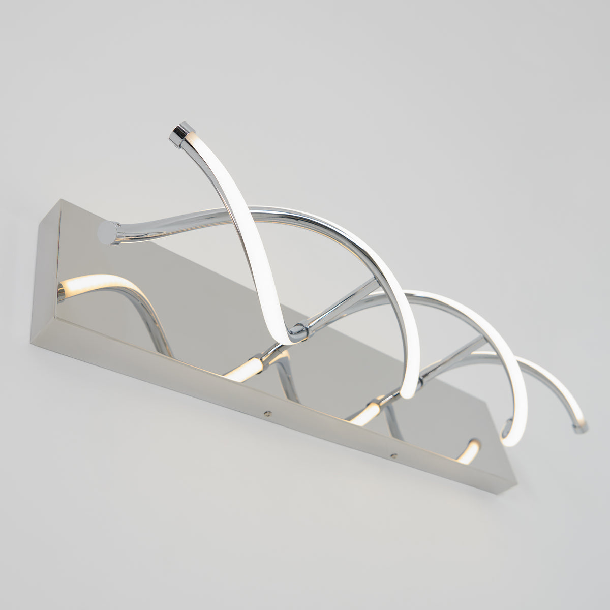 A modern chrome wall light fixture with three curved, illuminated LED arms arranged in an artistic, wave-like design on a rectangular base.