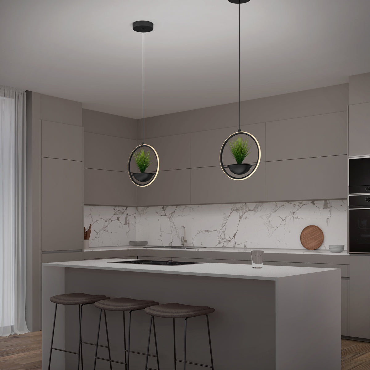 A modern kitchen with gray cabinets, a white marble backsplash, and a large island with three stools. Two circular pendant lights with potted plants hang above the island. A glass and a wooden cutting board sit on the counters.