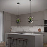A modern kitchen with gray cabinets, a white marble backsplash, and a large island with three stools. Two circular pendant lights with potted plants hang above the island. A glass and a wooden cutting board sit on the counters.