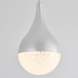The Artika Glitzer LED pendant light features a smooth, teardrop-shaped white fixture with a textured glowing lower half, suspended against a plain light gray background.