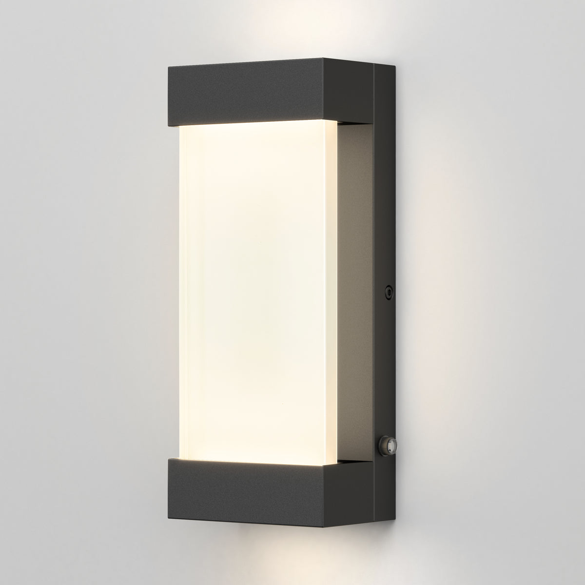The Artika Glacier indoor-outdoor LED wall light features a modern rectangular black metal frame with a frosted white center, mounted on a light gray wall and emitting a soft edge glow.