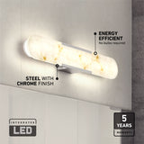 A wall-mounted LED light bar with a marble-like finish and chrome accents is lit on a gray wall. Text highlights its energy efficiency, steel with chrome finish, integrated LED, and 5-year warranty.