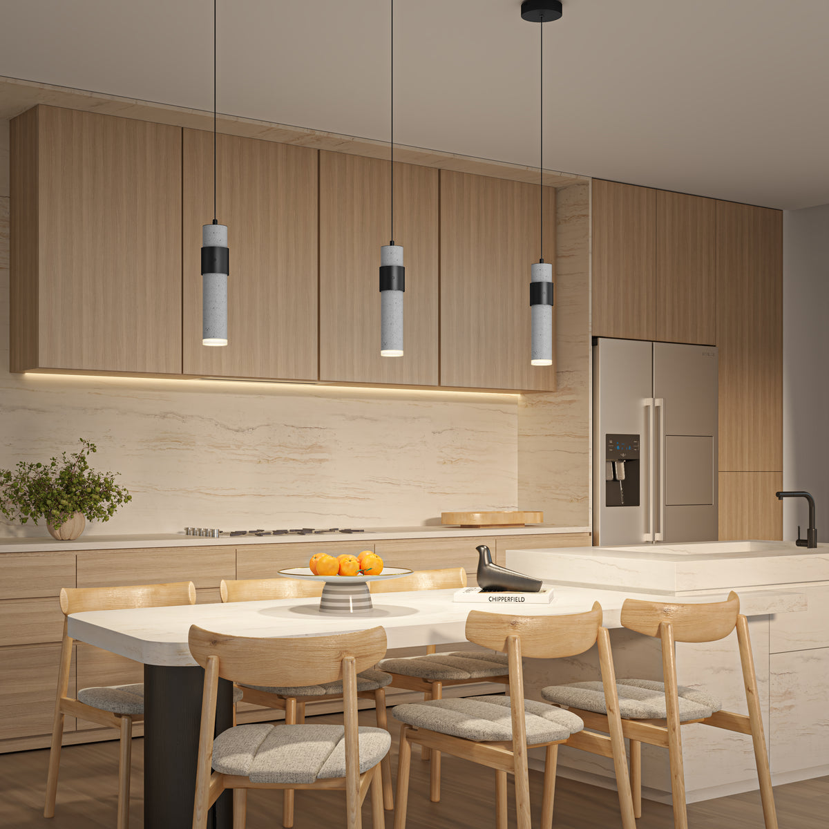 A modern kitchen with light wood cabinets, a marble backsplash, an island with a white countertop, six wooden chairs, a bowl of oranges, and three pendant lights hanging above the island.