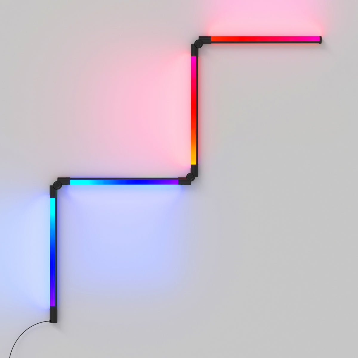 A modern LED wall light with four connected segments forming a zigzag pattern, each segment glowing in vibrant colors including red, pink, blue, and orange, mounted on a plain light-colored wall.