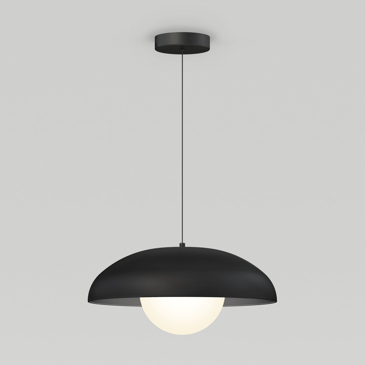 A modern pendant light with a black, dome-shaped shade and a glowing white bulb, suspended from the ceiling by a thin black cord against a plain light gray background.