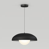A modern pendant light with a black, dome-shaped shade and a glowing white bulb, suspended from the ceiling by a thin black cord against a plain light gray background.
