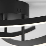 Close-up of a modern black ceiling light fixture with curved LED light strips and a round base against a white ceiling.