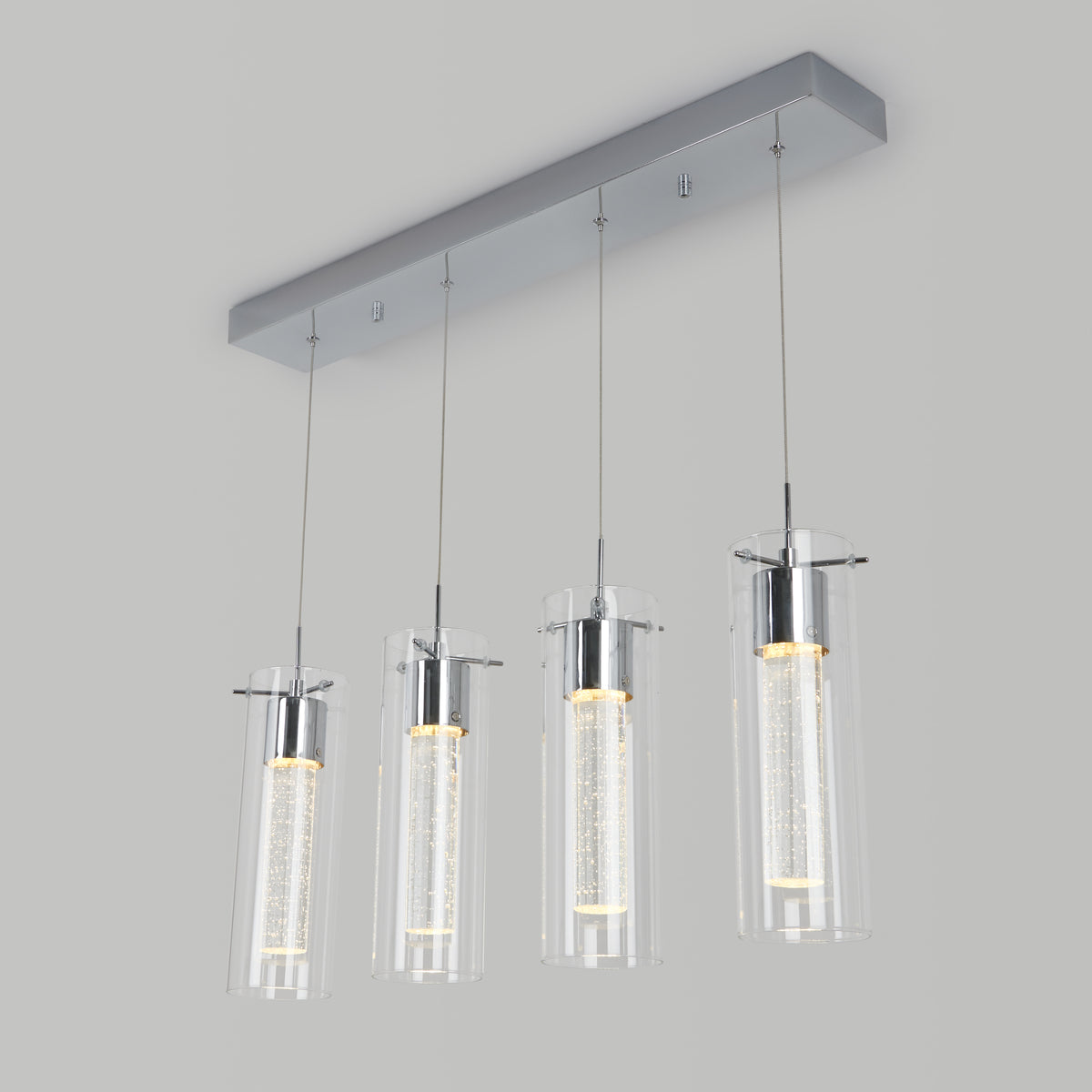 Modern ceiling light fixture with four cylindrical glass pendant lights hanging in a row from a rectangular metallic base, each containing an illuminated inner tube. The background is light gray.