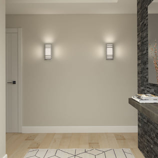 A minimalist hallway with light wood floors, beige walls, a geometric rug, a floating stone shelf with magazines and twigs, and two Artika Glowbox 3 indoor-outdoor LED wall lights.
