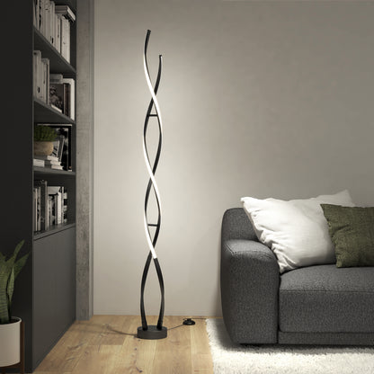 A modern living room with a gray sofa, white and green pillow, bookshelf, potted plant, and the Artika Swirl modern LED floor lamp—its twisted black and white design is lit against a neutral wall.