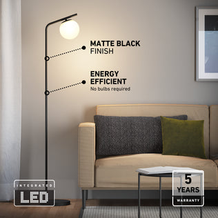 Artika Clayton dimmable LED modern mid-century floor lamp in matte black with a spherical white glass shade, energy efficiency labels, and warranty.