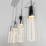 Four modern pendant lights with cylindrical glass shades and chrome accents hang in a row. The inner cylinders are illuminated, creating a sparkling effect with tiny lights inside.