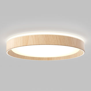 The Artika Callisto 15 in. LED flush mount light features a modern circular design with a light wood finish and glowing white center, installed on a plain, light-colored ceiling.