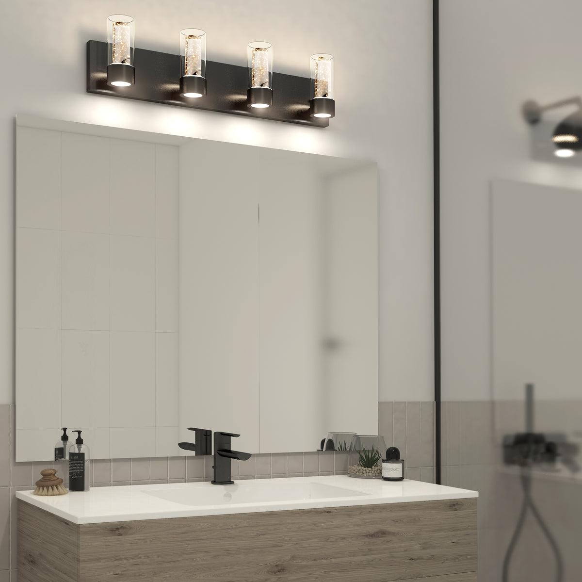 Modern bathroom vanity with an Artika Essence 27-in LED light, large mirror, sink, soap dispensers, and decorative plants on the counter.