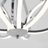 Close-up of a modern chandelier with curved, polished chrome arms and integrated LED light strips, set against a light grey background.
