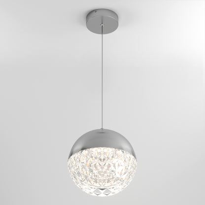 The Artika Carat LED pendant light 3 CCT features a modern design with a round silver top, faceted crystal-like bottom, and hangs by a thin cord, illuminating elegantly against a plain white ceiling.