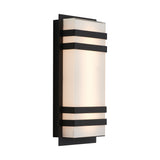 A modern rectangular wall sconce with frosted glass and black metal horizontal bands, mounted on a black rectangular backplate, emitting a soft, diffused light.