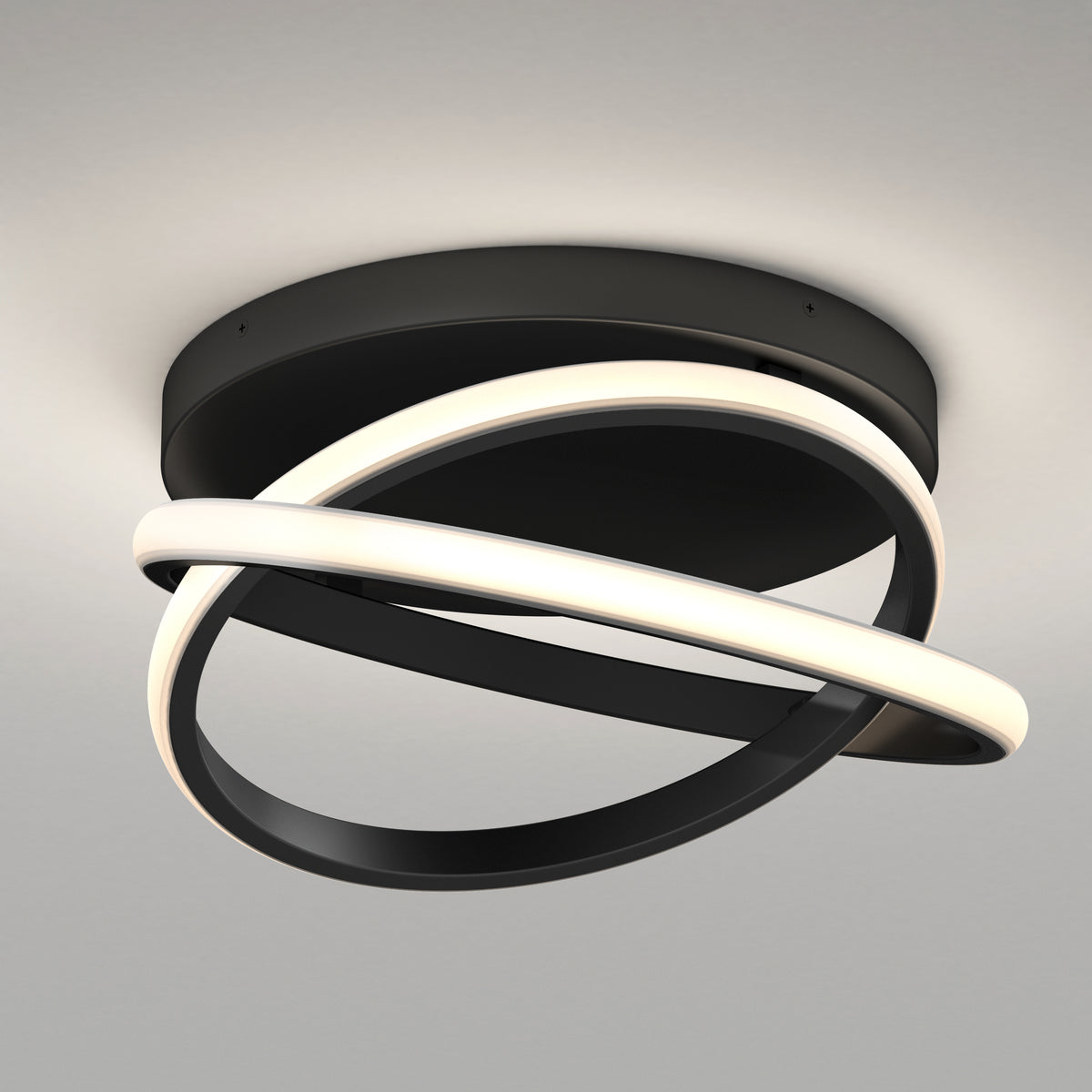 Modern ceiling light fixture with two interlocking oval rings, one emitting a soft white glow and the other a matte black band, mounted on a round black base against a light gray ceiling.
