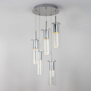 The Artika Essence 5-light LED pendant features five cylindrical glass fixtures at varying heights on a round chrome-accented base, showcasing visible LED filaments for a modern look.