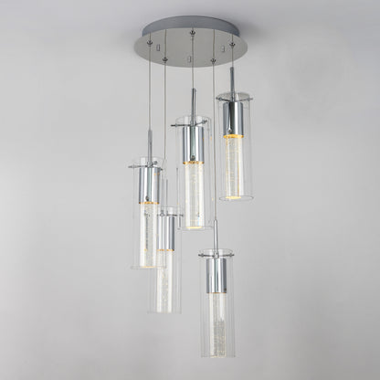 The Artika Essence 5-light LED pendant features five cylindrical glass fixtures at varying heights on a round chrome-accented base, showcasing visible LED filaments for a modern look.