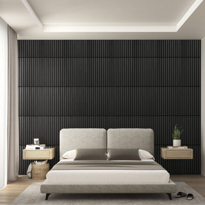 A modern bedroom features a large beige bed, light wood nightstands, and an Artika-CAN-dev Sonolok 15.5 ft sound-absorbing wall panel kit as a dark accent wall, with soft natural light through sheer curtains for a calm minimalist feel.