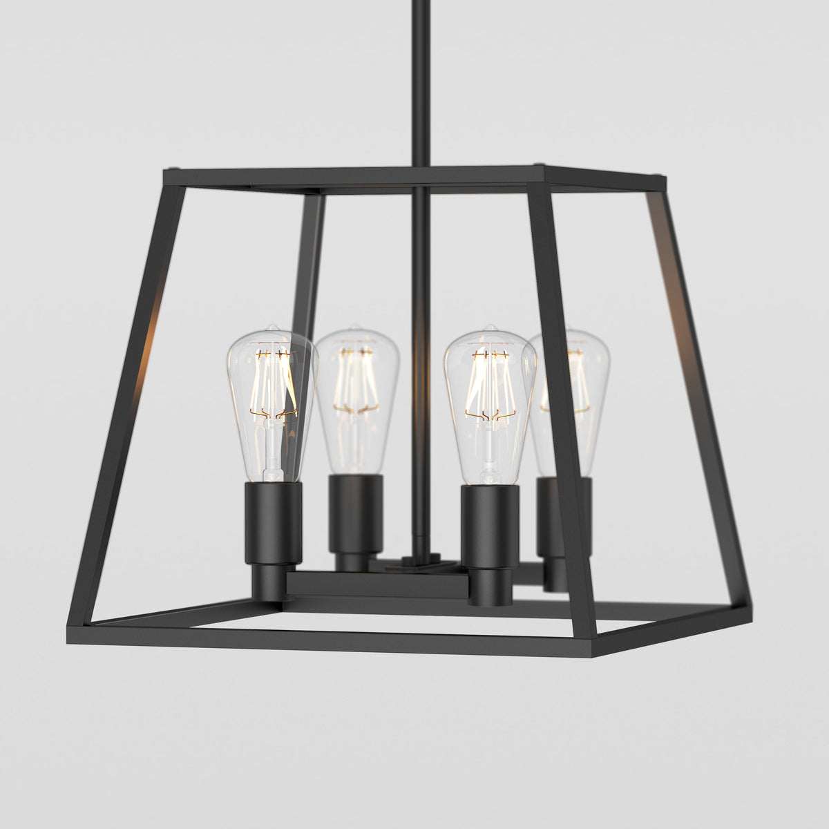 A modern black metal pendant light fixture with a geometric open frame design, featuring four exposed vintage-style Edison bulbs arranged in the center. The background is plain and light-colored.
