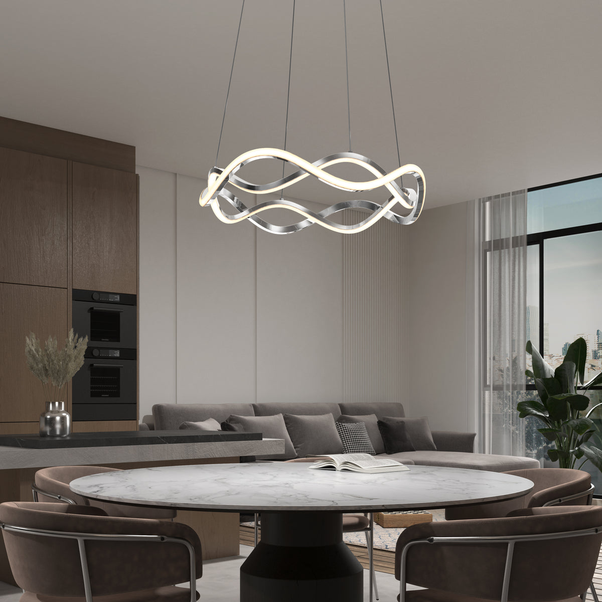 Modern dining area featuring a round marble table, brown chairs, and the Artika Vanora LED pendant light (5 CCT) as a sculptural centerpiece. In the background: gray sofa, large windows, and wooden cabinetry with built-in ovens.